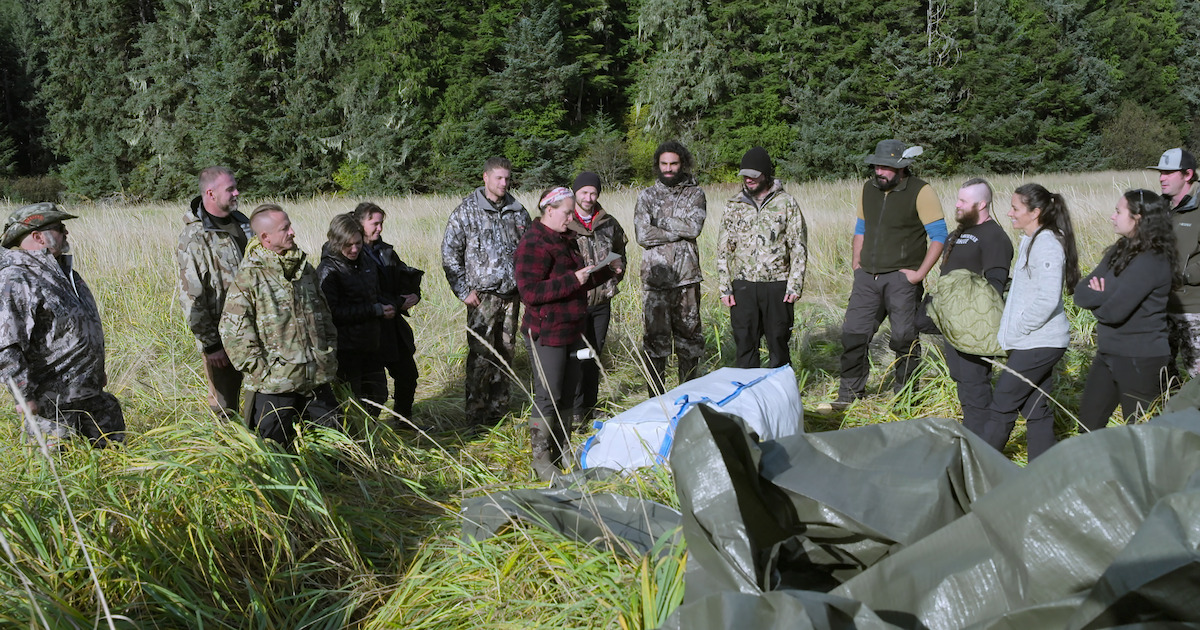 A group of men and women standing in a field