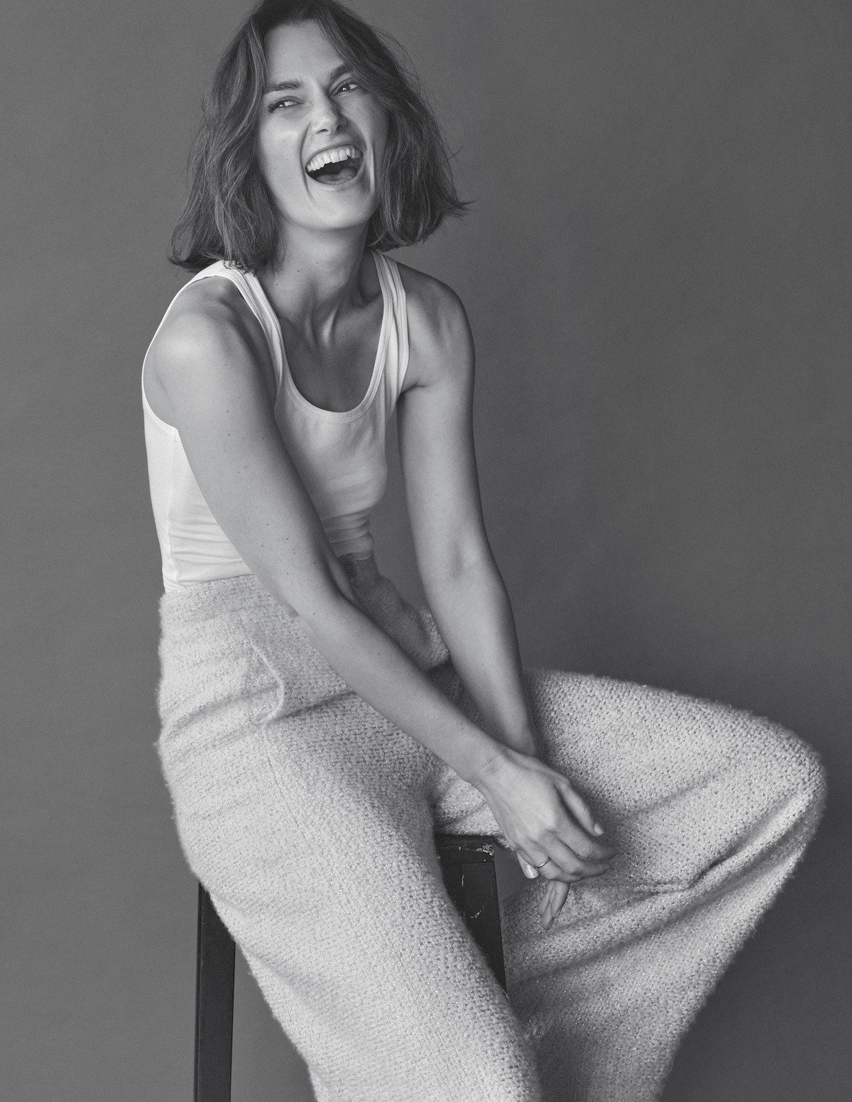 Keira Knightley wears a white tank and knit pants.
