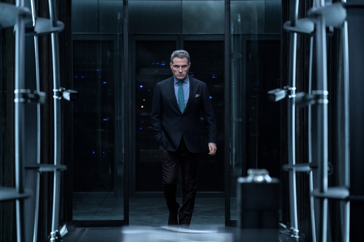 A man walking through a vault door.