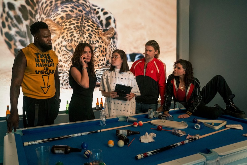 Terrence Terrell as Trunk, Shelley Hennig as Ava Winters, Kimi Rutledge as Maya Lerner, Nick Zano as Chad McKnight, and Paola Lázaro as Angela Gomez stand around a pool table together in Season 1 of 'Obliterated.'