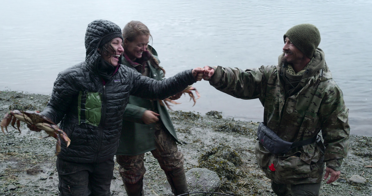 a woman holding a crab and dapping a friend