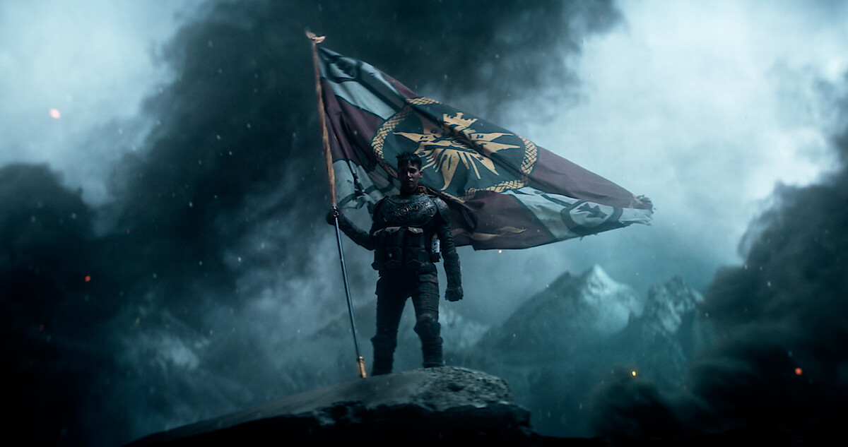 A person holding a flag surrounded by smoke